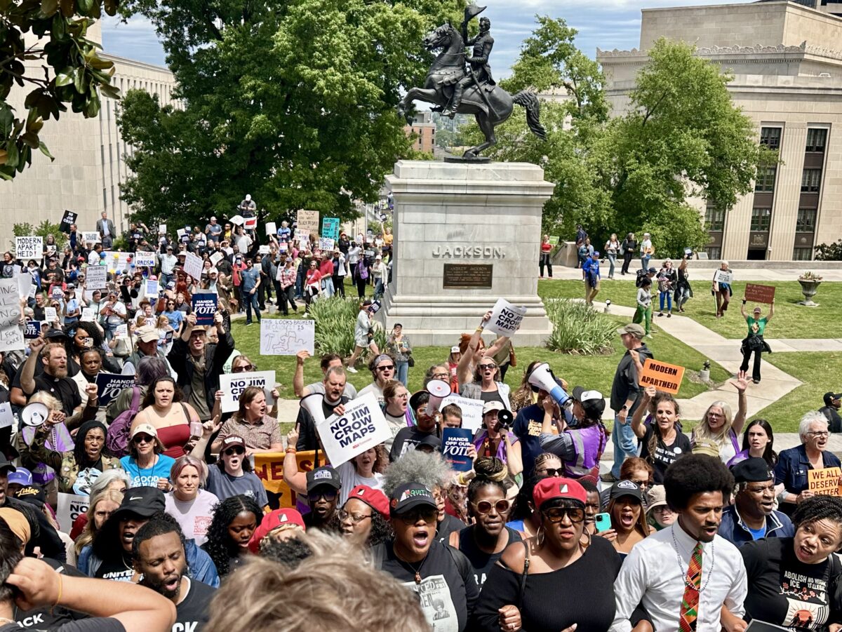 A crowd of protesters marches up the steps of the Tennessee State Capitol, past a statue of President Andrew Jackson. (The Progressive South)